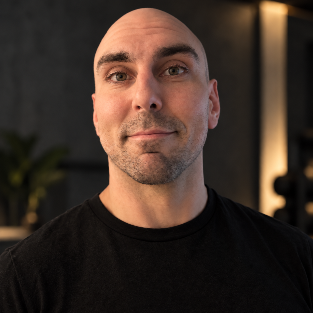Professional portrait of Alex Fearnley looking toward the camera, with natural skin texture and subtle warm studio lighting.